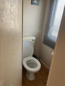 a white toilet in a bathroom with a window at Julie's in Ingoldmells