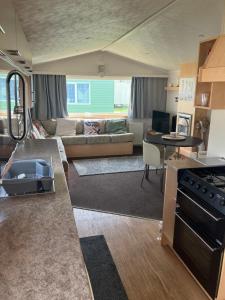 a kitchen and living room with a couch and a table at Julie's in Ingoldmells +2 photos