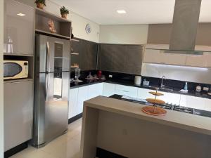 a kitchen with a stainless steel refrigerator and a counter at Espaço MGS in Foz do Iguaçu