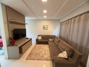 a living room with a couch and a flat screen tv at Espaço MGS in Foz do Iguaçu