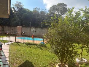 a swimming pool in a park with a tree at Espaço MGS in Foz do Iguaçu
