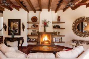 a living room with a fireplace and white furniture at Casa Grande Luxury Boutique Hotel in San Miguel de Allende