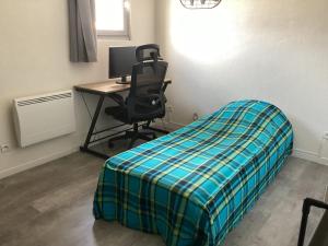 a bedroom with a bed and a desk with a computer at Celimène in Canet-en-Roussillon