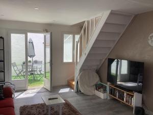 a living room with a staircase with a tv at Celimène in Canet-en-Roussillon