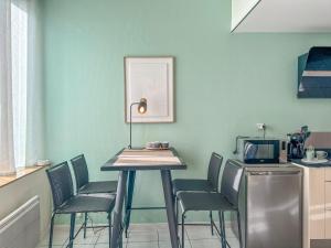 a kitchen with a table with chairs and a microwave at Cocon en Chartreuse in Voreppe +7 photos