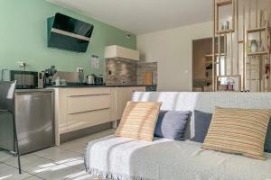 a living room with a couch and a kitchen at Cocon en Chartreuse in Voreppe
