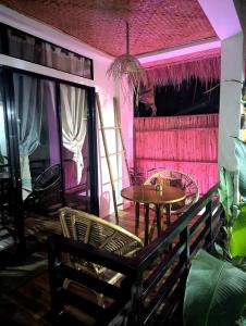 a room with a table and chairs and pink lighting at Maison PAYAPA PORT BARTON in San Vicente