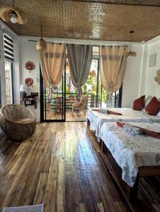 a bedroom with two beds and a chair in it at Maison PAYAPA PORT BARTON in San Vicente