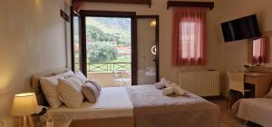a bedroom with a bed with a view of a balcony at Karras Apartments in Gliki +64 photos