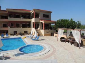 a swimming pool in front of a building at Karras Apartments in Gliki