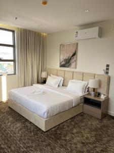 a bedroom with a large white bed with two lamps at فندق لوسكا in Abha