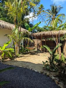 a resort with a straw hut and palm trees at Maison PAYAPA PORT BARTON in San Vicente