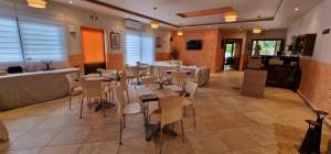 a restaurant with tables and chairs in a room at Karras Apartments in Gliki