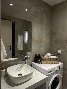 a bathroom with a washing machine and a sink at Kostas apartaments in Korinthos
