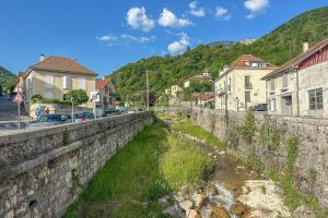 a river in a town with houses and buildings at Cocon en Chartreuse in Voreppe
