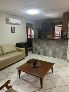a living room with a couch and a coffee table at Vilarejo do farol in Praia do Forte