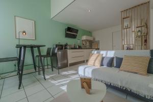 a living room with a couch and a kitchen at Cocon en Chartreuse in Voreppe