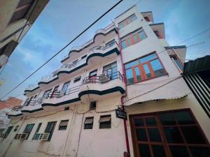 a tall white building with windows and balconies on it at Gaurav Boarding House in Mathura