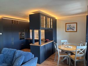 a living room with a blue couch and a table at Harbour Mill Apartment in Westport