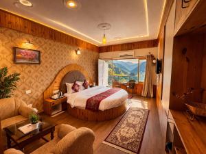 a hotel room with a bed and a living room at Manali Valley Resort in Manāli