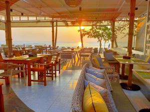 a restaurant with tables and chairs and the ocean at The Fair House Beach Resort & Hotel in Chaweng Noi Beach