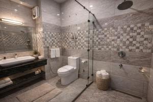 a bathroom with a toilet and a shower and a sink at Manali Valley Resort in Manāli +31 photos
