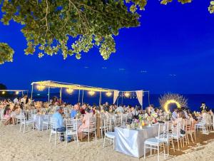 a group of people sitting at tables on the beach at The Fair House Beach Resort & Hotel in Chaweng Noi Beach +124 photos