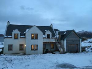 a house in the snow with a mountain in the background at Dun Caan Apartment in The Braes
