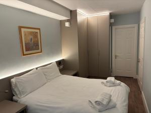 a bedroom with a white bed with two towels on it at Harbour Mill Apartment in Westport