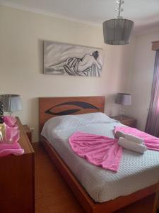 a bedroom with a bed with a pink blanket on it at Casa MiraMar in Rabo de Peixe
