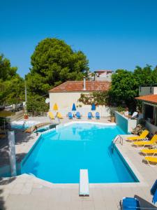 ein großes Schwimmbad mit Stühlen und einem Gebäude in der Unterkunft Villa Pefki in Chania