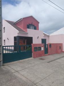 a red and white house with a green gate at Casa MiraMar in Rabo de Peixe