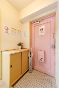 a room with a pink door and a counter at Orange Stay Matsuyama in Matsuyama