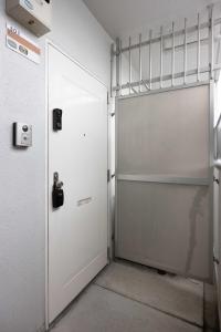 a white garage door in a room at Orange Stay Matsuyama in Matsuyama