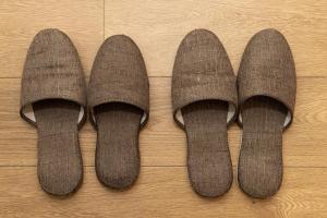 three pairs of brown socks on a wooden floor at Orange Stay Matsuyama in Matsuyama
