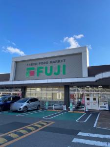 a store with cars parked in a parking lot at Orange Stay Matsuyama in Matsuyama