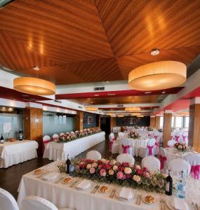 a banquet hall with white tables and chairs and flowers at Hospedium Hotel Juan II in Toro