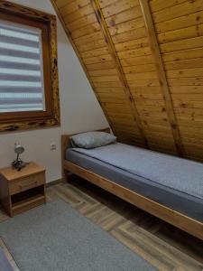 a bed in a room with a wooden ceiling at Vlasic Odmor - Villa Krajina III in Vlasic