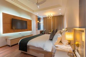 a bedroom with a large bed and a flat screen tv at Ranveer The Garden Resort in Haldwāni
