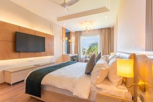 a bedroom with a large bed with a flat screen tv at Ranveer The Garden Resort in Haldwāni