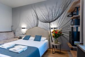 a bedroom with a bed and a vase of flowers at Hotel Central Giacomini in Salò +88 photos