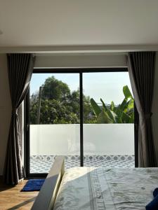 a bedroom with a large window with a view at Lisa House Phu Quoc in Phú Quốc