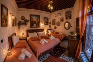 a bedroom with two beds in a room at Riad T-A-J Fès Crown in Fez