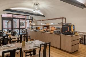 a restaurant with tables and chairs and a counter at Hotel Central Giacomini in Salò