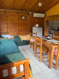 a room with a table and a bed and a kitchen at cabañas los juanes in Tres Arroyos +13 photos