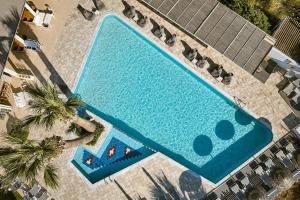 an overhead view of a swimming pool with palm trees at Hara Ilios Village in Gouves