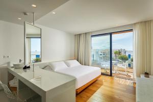 a bedroom with a bed and a desk with a view at Hara Ilios Village in Gouves
