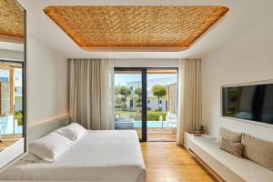 a bedroom in a villa with a bed and a tv at Hara Ilios Village in Gouves