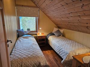 two beds in a small room with a window at Huset ved Dalsfjorden in Helle