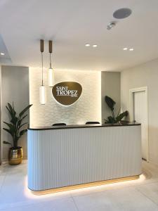 a lobby with a counter with a sign on it at Hotel Saint Tropez in Riccione